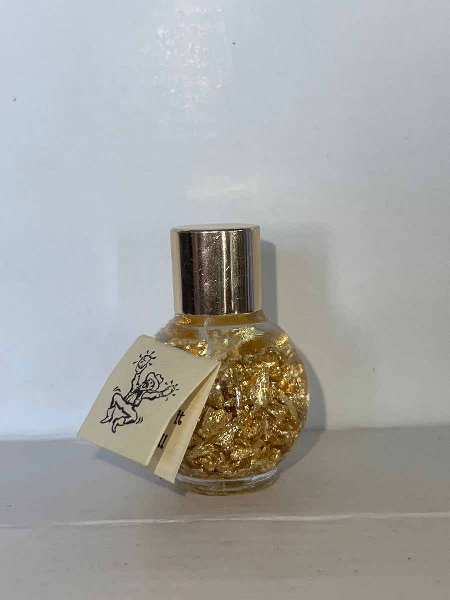 Captivating bottle of gold flakes, suspended in liquid, available at natur.